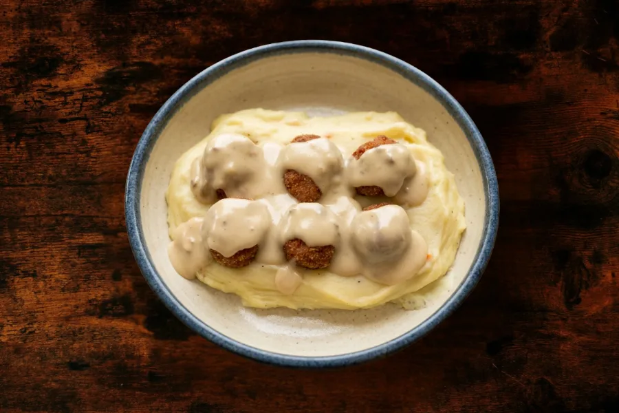 Mini meatballs on mashed potatoes, with mushroom sauce