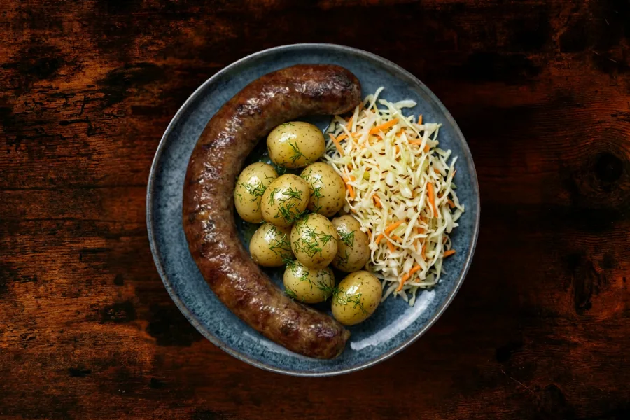 Grilled beef sudzhuk (100% beef) served with fresh potatoes with dill, and a cabbage and carrot salad.